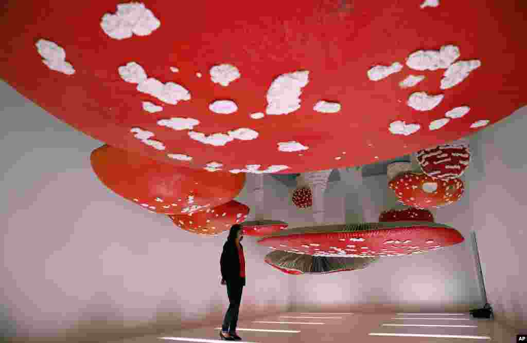 A woman looks at the installation &quot;Upside Down Mushroom Room&quot; by Carsten Holler, part of the Design Week, at the Prada&#39;s foundation, in Milan, Italy.