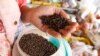 A vendor holds a handful of Kampot pepper before selling at a market in Phnom Penh, Cambodia, Tuesday, March 1, 2016.