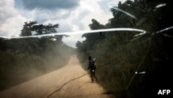 Un homme marche sur la route de transport qui relie la ville de Bunia à la ville minière de Mambasa, dans la province de l’Ituri, le 10 juillet 2018.