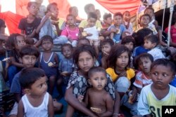 Anak-anak pengungsi Rohingya duduk di dek kapal mereka yang berlabuh di perairan dekat pantai Labuhan Haji, provinsi Aceh, Indonesia, Selasa, 22 Oktober 2024. (Binsar Bakkara/AP)