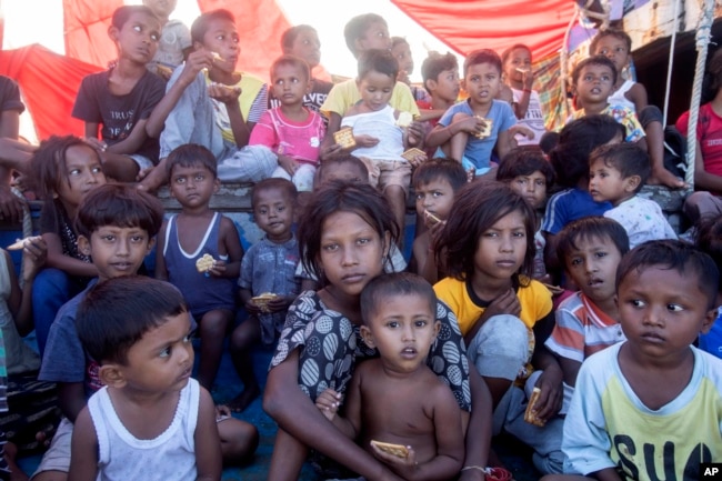 Anak-anak pengungsi Rohingya duduk di dek kapal mereka yang berlabuh di perairan dekat pantai Labuhan Haji, provinsi Aceh, Indonesia, Selasa, 22 Oktober 2024. (Binsar Bakkara/AP)