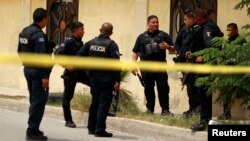 Police officers guard a crime scene where the bodies of several people were found inside a house, days before the visit of Mexico's President-Elect Andres Manuel Lopez Obrador, in Ciudad Juarez, Aug. 3, 2018. 
