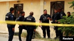 Police officers guard a crime scene where the bodies of several people were found inside a house, days before the visit of Mexico's President-Elect Andres Manuel Lopez Obrador, in Ciudad Juarez, Aug. 3, 2018. 