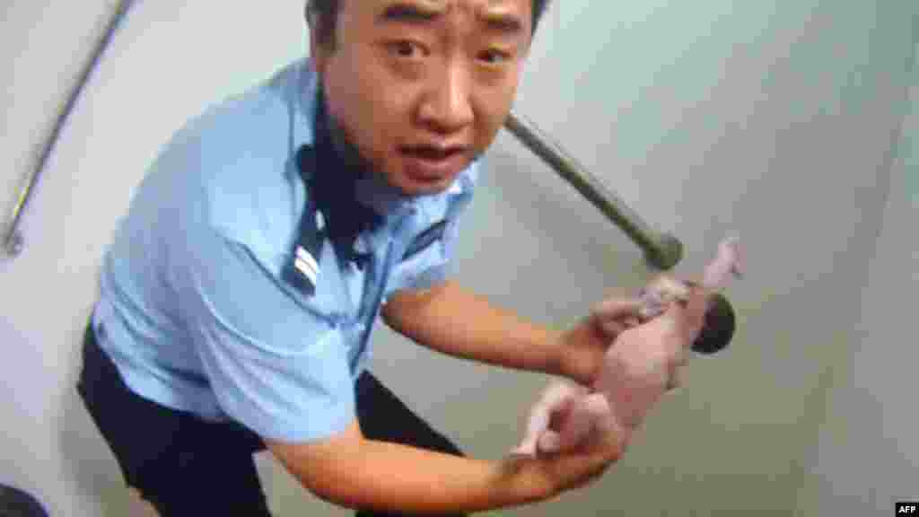 This frame grab of a police video taken on August 2, 2015 shows a policeman holding an abandoned newborn baby in a public toilet in Beijing. A newborn baby girl was abandoned in a Beijing public toilet and fell head-first down the pipe, reports said August 3, after her mother apparently gave birth in the facility.