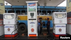 Một nhân viên đang đổ xăng cho một chiếc xe buýt tại một cây xăng ở thành phố Kolkata, Ấn Độ
