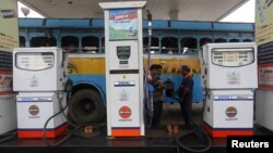 An employee fills diesel in a public bus at a fuel station in Kolkata, August 13, 2012. 