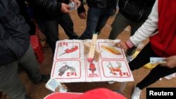 FILE - Residents place money during an illegal game of chance at a village outside Hanoi, Feb. 12, 2014. Vietnamese are passionate gamblers, from clandestine card games to bets on European soccer with underground bookies.