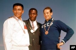 FILE - This Sept. 6, 1960, photo shows the top three finishers in the decathlon of the 1960 Rome Summer Olympics at Olympic Stadium in Rome: Rafer Johnson, Yang Chuan and Vasili Kuznetsov.