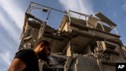 A man surveys damage to a building where emergency services said 11 people were hurt by shrapnel and glass shards in a direct strike by projectiles fired from Lebanon, in Tira, central Israel, on Nov. 2, 2024.