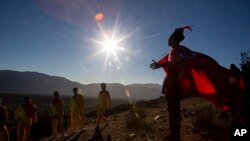 En esta imagen, tomada el 1 de julio de 2019, un joven vestido de chamán se prepara para participar en una sesión de fotos antes del eclipse total de sol, en La Higuera, Chile.