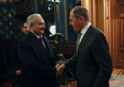 FILE - This handout picture released by the Russian Foreign Ministry Jan. 13, 2020, shows Russian Foreign Minister Sergey Lavrov welcoming Libyan military strongman Khalifa Haftar in Moscow.