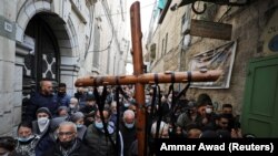 Umat Kristen dalam prosesi Jumat Agung di sepanjang Via Dolorosa di tengah pembatasan COVID-19, selama Pekan Suci Paskah di Kota Tua Yerusalem, 2 April 2021. (Foto: REUTERS/Ammar Awad)