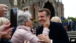 Francuski predsjednik Emmanuel Macron smiješi se pristalicama nakon što je glasao na europskim parlamentarnim izborima u Le Touquetu, sjeverna Francuska, 26. maj 2019. godine. 