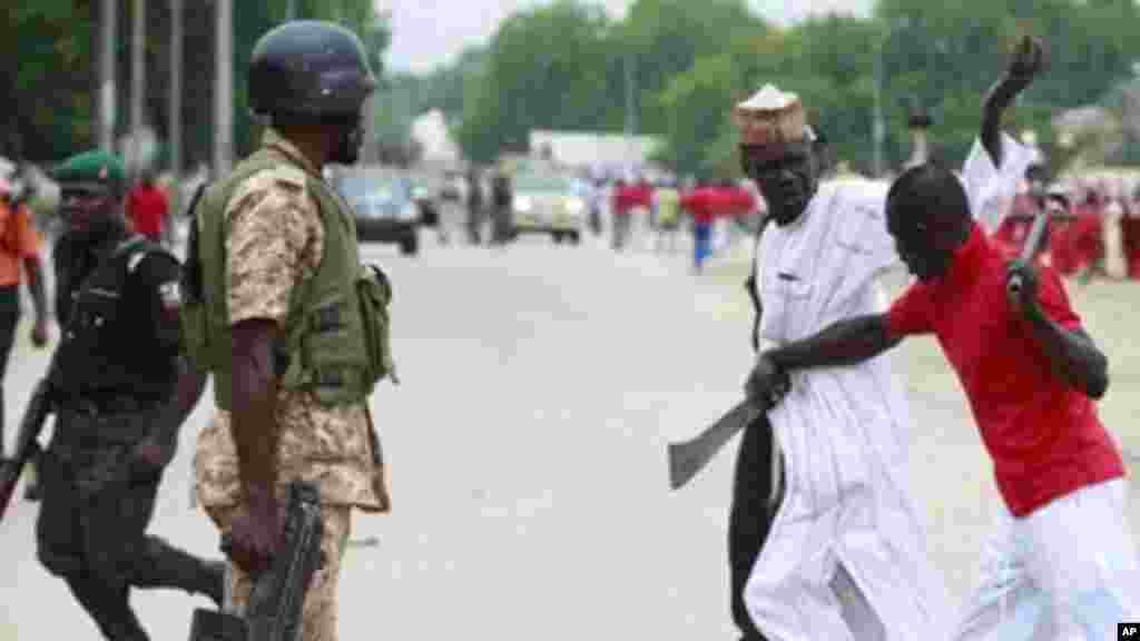 'Yan bangan Fararen Hulan JTF suna anfani ne da kulake da sanduna da makaman da aka sarafa cikin gida suna sintiri a kan titunan Maiduguri, Najerya.