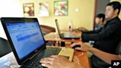 Cambodian men using the Internet at a coffee shop in Phnom Penh.
