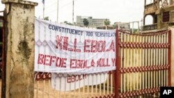In this photo taken on Sunday, Sept. 14, 2014, a sign reading 'Kill Ebola Before Ebola Kill You', on a gate forming part of the country's Ebola awareness campaign in the city of Freetown, Sierra Leone. Shoppers crowded streets and markets in Sierra Leone's capital on Thursday, Sept. 18, stocking up for a three-day shutdown that authorities will hope will slow the spread of the Ebola outbreak that is accelerating across West Africa. 