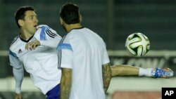 Argentina's Lionel Messi, left, kicks the ball next to teammate Ezequiel Lavezzi during an official training session at Vasco da Gama Stadium a day before the World Cup soccer final between Germany and Argentina in Rio de Janeiro, Brazil, July 12, 2014. 