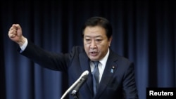 Japan's Prime Minister Yoshihiko Noda raises his fist as he makes a speech to his party's lawmakers at his party's meeting after the dissolution of the lower house in Tokyo, November 16, 2012.