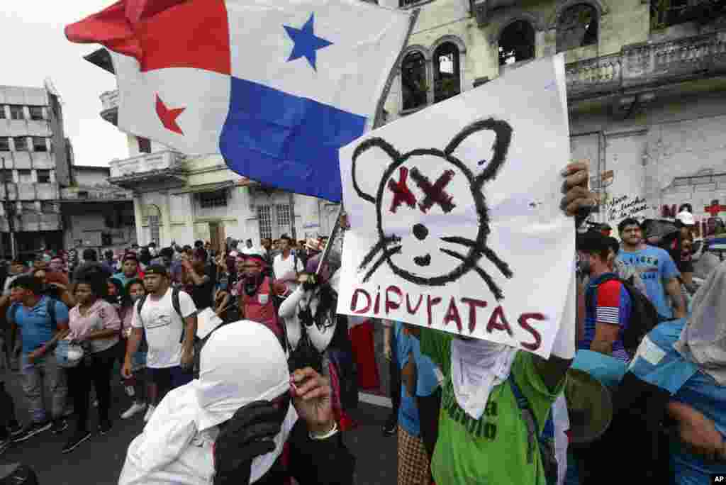 Estudiantes universitarios se reúnen fuera de la Asamblea Nacional para protestar por las reformas constitucionales propuestas, con un letrero que llama a los legisladores ratas. 