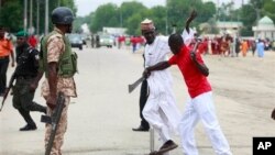 'Yan bangan Fararen Hulan JTF suna anfani ne da kulake da sanduna da makaman da aka sarafa cikin gida suna sintiri a kan titunan Maiduguri, Najerya.