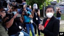 FILE - Rappler CEO Maria Ressa stands in front of reporters outside the Court of Tax Appeals in Manila, Philippines, March 4, 2021. 