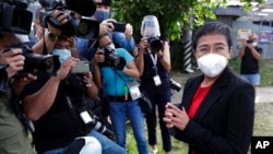 FILE - Rappler CEO Maria Ressa stands in front of reporters outside the Court of Tax Appeals in Manila, Philippines, March 4, 2021.