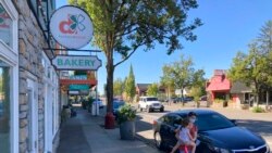 A woman and her child walk through downtown Newberg, Ore., Sept. 21, 2021.