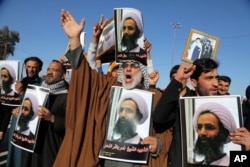 Iraqi Shiite protesters chant slogans against the Saudi government as they hold posters showing Sheikh Nimr al-Nimr, who was executed in Saudi Arabia last week, during a demonstration in Najaf, south of Baghdad, Iraq, Jan. 4, 2016.