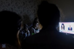 People watch TV in a bomb shelter in Stepanakert, the capital of the breakaway Nagorno-Karabakh region, in this picture released Sept. 28, 2020. (Foreign Ministry of Armenia/Handout via Reuters)