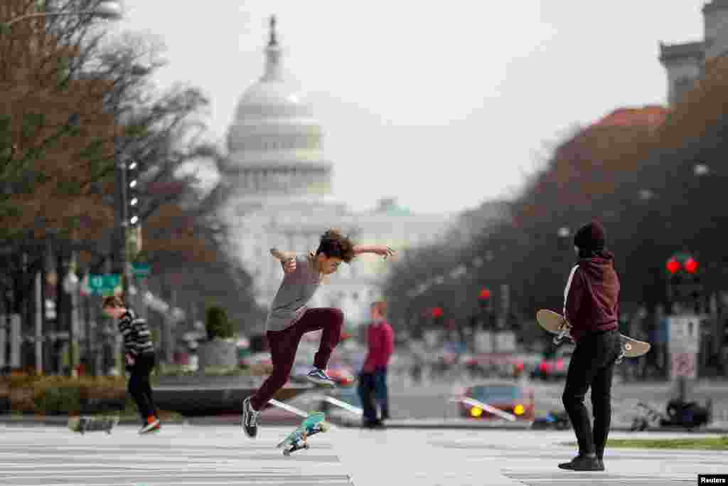 Kids perform skateboard tricks at Freedom Plaza after Mayor Muriel Bowser declared a State of Emergency due to the coronavirus pandemic, in Washington, March 16, 2020.
