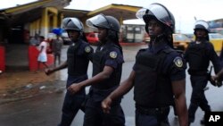 Police chant as they march through the streets of central Monrovia, Liberia, Oct. 11, 2011.