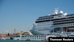 FILE - The cruise ship MSC Opera loses control and crashes against a smaller tourist boat at the San Basilio dock in Venice.