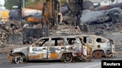 Mobil-mobil yang terbakar hangus terlihat di dekat lokasi ledakan tangki minyak di Lac Megantic, Quebec, Kanada (9/7).