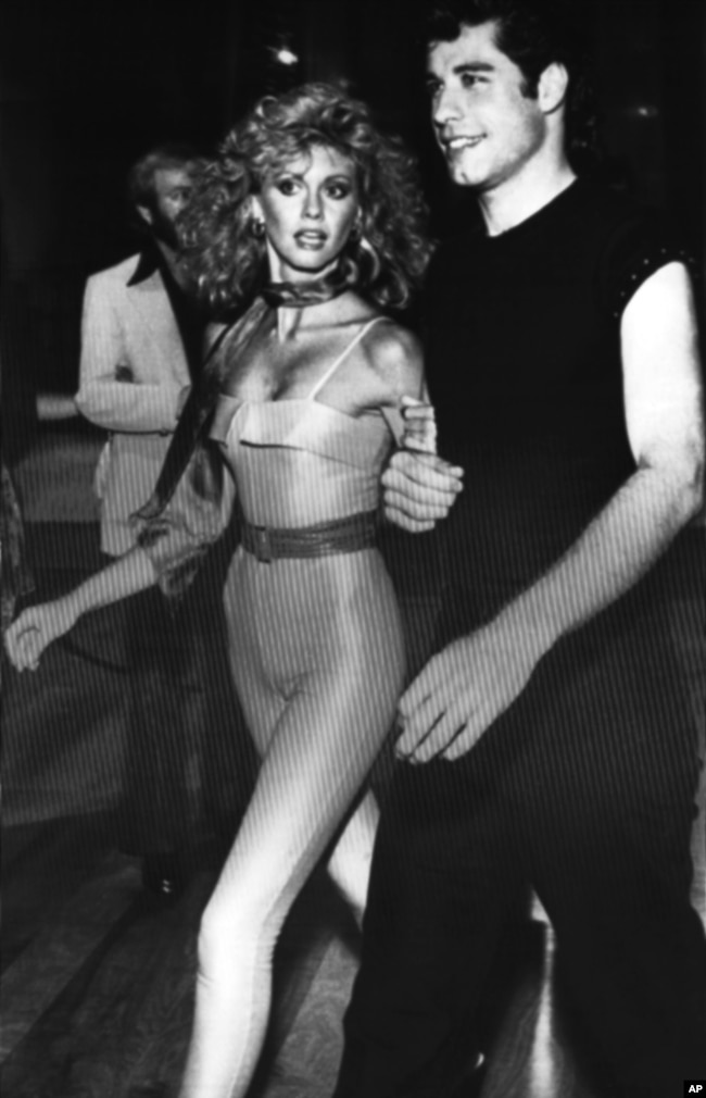 Olivia Newton-John and John Travolta walk through the crowd of guests at a party following the premiere of their new movie Grease?in Los Angeles on June 5, 1978. (AP Photo)