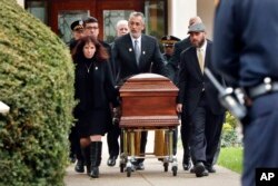 Pittsburgh police stand guard as the casket of Irving Younger, 69, is wheeled from Congregation Rodef Shalom after his funeral on Oct. 31, 2018, in Pittsburgh.