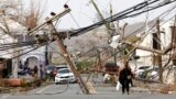 Residents and cars make their way around and under obstacles blocking a main road nearly a week after Hurricane Maria raked the island, in Frederiksted, St. Croix, U.S. Virgin Islands September 26, 2017.