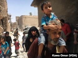 FILE - Iraqi civilians flee fighting against Islamic State militants in the Old City of Mosul, Iraq, July 1, 2017.