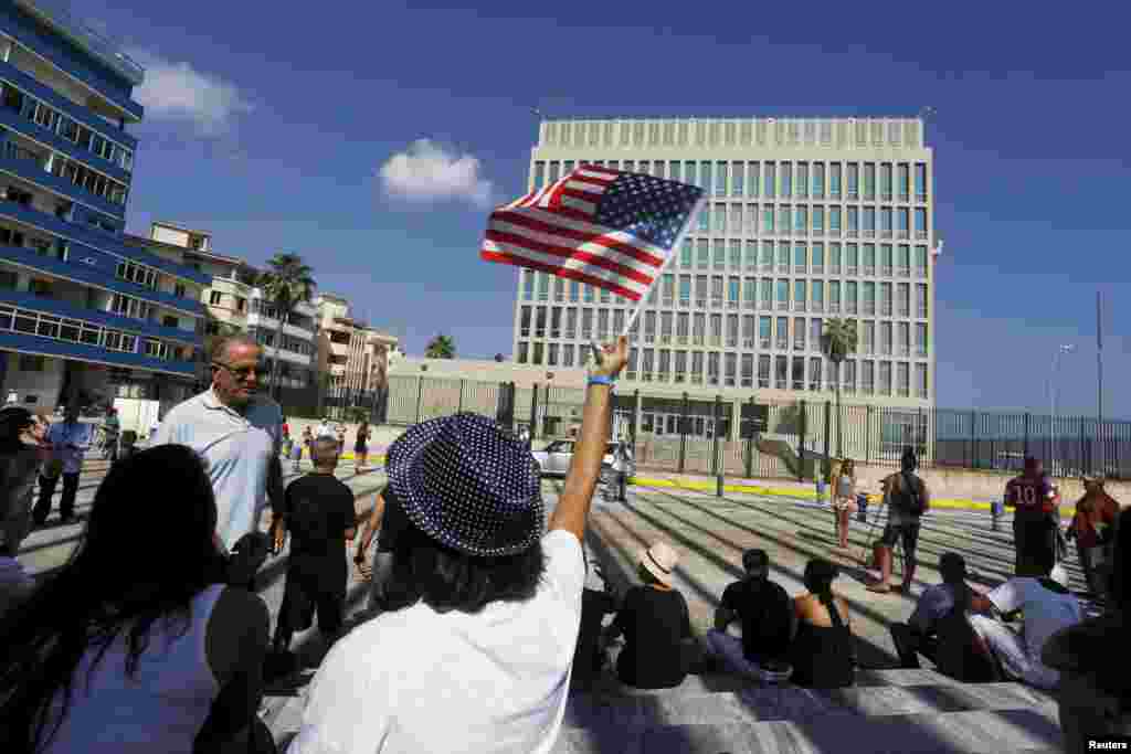 A woman waves a U.S flag in front of the U.S. Interests Section, in Havana, July 20, 2015.