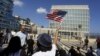 FILE - A woman waves a U.S flag in Havana, July 20, 2015.