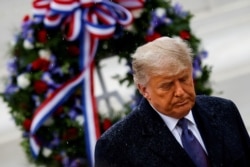 U.S. President Donald Trump departs after placing a wreath at the Tomb of the Unknown Solider as he attends a Veterans Day observance in the rain at Arlington National Cemetery in Arlington, Virginia, Nov. 11, 2020.