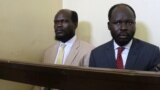 FILE - Kerbino Wol, left, a businessman, and Peter Biar Ajak, the South Sudan country director for the London School of Economics International Growth Centre based in Britain, sit inside the courtroom in Juba, South Sudan March 21, 2019.