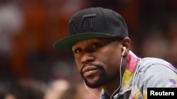 FILE - Boxer Floyd Mayweather Jr. is seen during the first half between the Miami Heat and the Toronto Raptors at American Airlines Arena, Miami, Florida, April 11, 2018. 