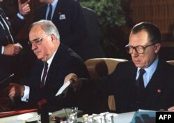 FILE - German Chancellor Helmut Kohl, left, and European Commission President Jacques Delors organize documents before the opening session of the European Summit in Luxembourg on June 28, 1991.