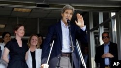 Menteri Luar Negeri AS John Kerry melambaikan tangan setelah berbicara kepada wartawan di Boston (12/6). (AP/Elise Amendola)