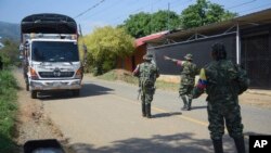 ARCHIVO - Guerrilleros de las FARC-EMC detienen un camión mientras hacen cumplir un bloqueo vial en Corinto, Colombia, el viernes 12 de abril de 2024, un día después de que un coche bomba explotara en la cercana ciudad de Miranda.