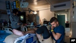 FILE - Israeli soldier Jonathan Ben Hamou, 22, wounded in the war with Hamas, sits in his room at Sheba hospital's rehabilitation division, in Ramat Gan, Israel, December 18, 2023.