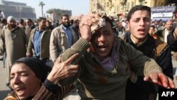 A wounded demonstrator is evacuated from Cairo's main square, Egypt, Wednesday, Feb.2, 2011. Several thousand supporters of President Hosni Mubarak, including some riding horses and camels and wielding whips, clashed with anti-government protesters as Egy