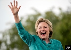 Democratic presidential candidate Hillary Clinton waves as she cuts her speech short because of heavy rain at a rally at C.B. Smith Park in Pembroke Pines, Fla., Nov. 5, 2016.