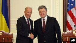 Wakil Presiden AS Joe Biden (kiri) dan Presiden Ukraina Petro Poroshenko berpose dalam konferensi gabungan di Kyiv (16/1). (AP/Sergei Chuzavkov)