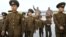 2017年4月25日，朝中社發布的照片​​顯示， 在北韓建軍節，北韓軍人走在前領導人人今日成和金正日的青銅像前面